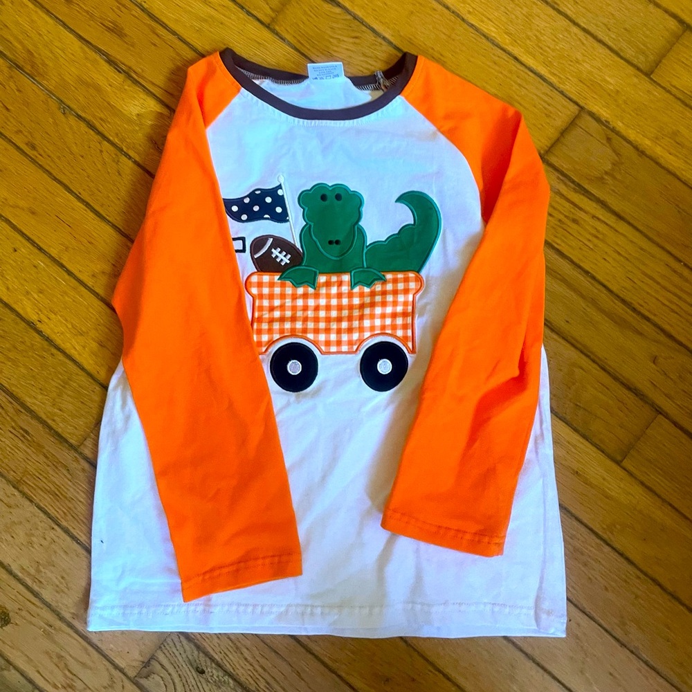 New size 7 Dino Football top